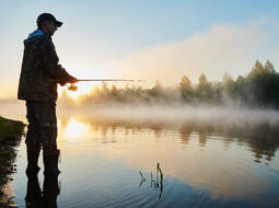 fisher fishing on foggy sunrise