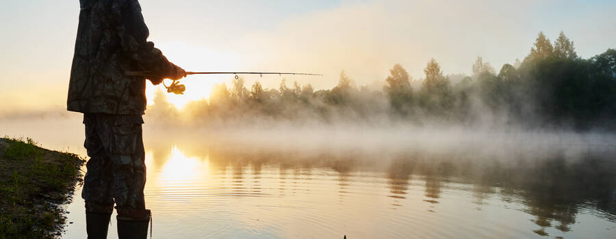 fisher fishing on foggy sunrise